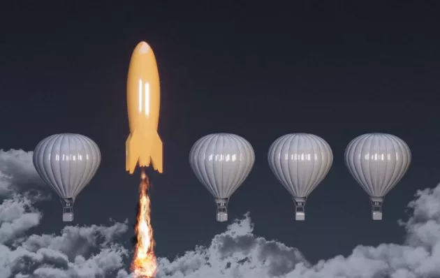 Image of an orange rocket and grey hot air balloons