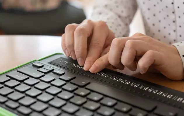 hands typing on a braille keyboard