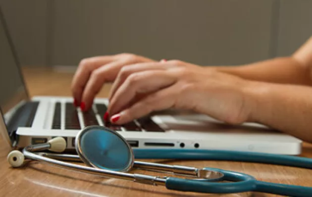 Hands typing on a laptop