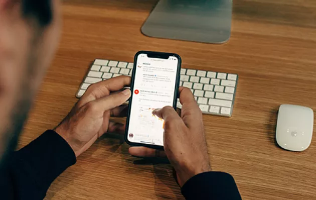 Photo of a person reading twitter on a phone